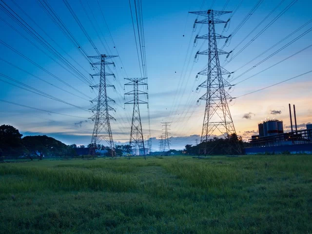 Sunset view of electricity pylons, showcasing the integration of energy storage batteries and hybrid power solutions.