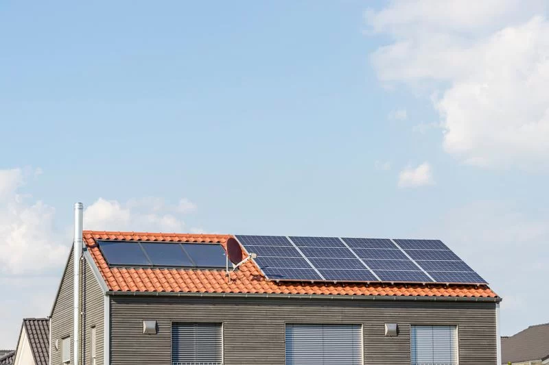 Home with solar panels made of monocrystalline material, including a solar panel battery for household energy storage.