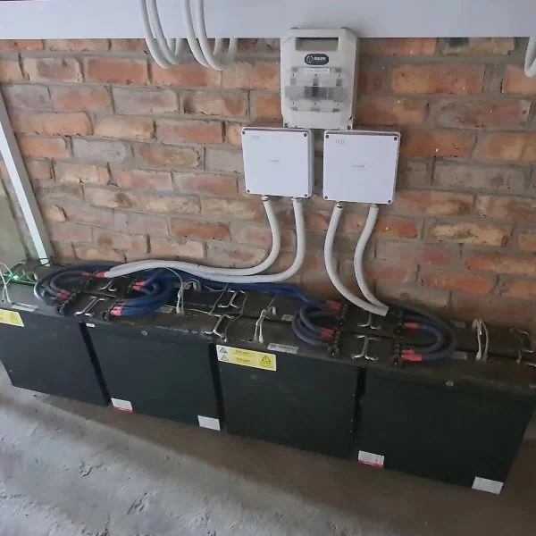 Lithium batteries for inverters attached to brick wall.