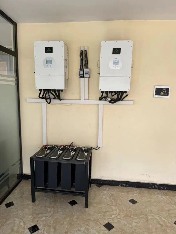 Two power inverters mounted on a wall in a room, with a battery for home use.