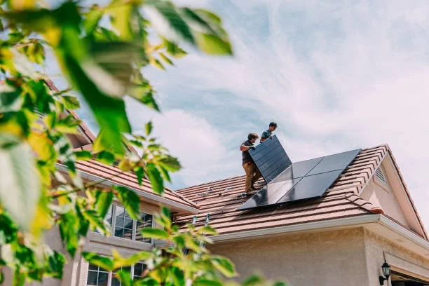 A man working on installing solar panels on a residential roof.