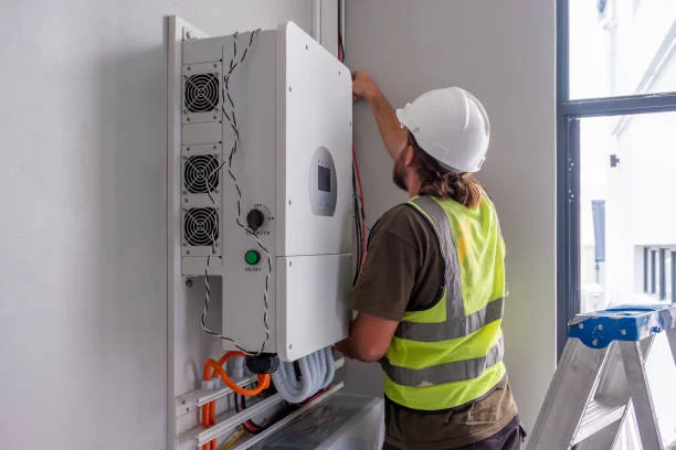 Worker installing an inverter at a site